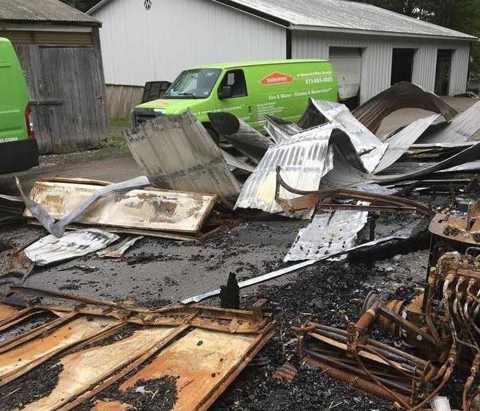 Damaged area by storm, Servpro vehicles passing through debris on a neighborhood area in Montclair, NJ